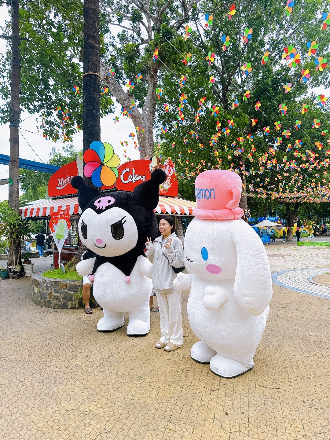 Kuromi and Cinnamoroll inflatable mascots in use at an outdoor venue with happy customer